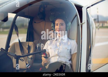 Chinese pilot sitting in helicopter cockpit Stock Photo