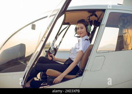 Chinese pilot sitting in helicopter cockpit Stock Photo