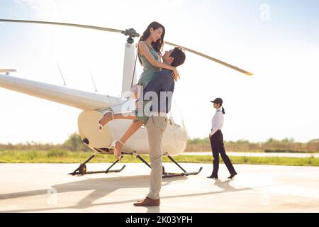 Young Chinese couple travelling by helicopter Stock Photo