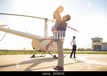 Young Chinese couple travelling by helicopter Stock Photo