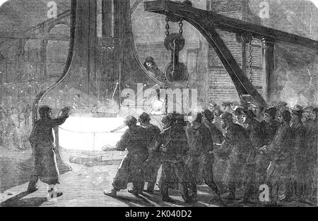 Iron Ship Fitting at the Royal Dockyard, Woolwich, 1854. Metalworking in London during the Crimean War. '...preparation of engines of the Termagant, 620-horse power...To form the cranks on the shaft, a quantity of scrap-iron is...put into the furnace, and when hot [is] welded under the 60 cwt. Nasmyth's hammer...when taken from the furnace and placed under the hammer, the heat of it is so intense that only those accustomed to the work could approach it. The shaft and cranks being forged, are finished in the Turning-shop to the exact dimension. The power transmitted through this shaft is equal Stock Photo