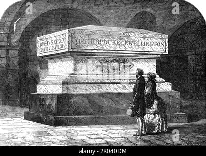 Tomb of the late Duke of Wellington, in the Crypt of St. Paul's Cathedral, [London], 1854. 'At the time of the Duke's funeral much difference of opinion existed as to the part of the Crypt in which his remains should be placed...The coffin has now been moved down an inclined plane from the centre of the Cathedral to the position shown...which is in the middle of a square chamber about 40 feet to the east...The resting-place of the Duke will thus form a centre round which other soldiers may be most honourably placed. The tomb, which has been designed by Mr. Penrose, will be executed in black ma Stock Photo