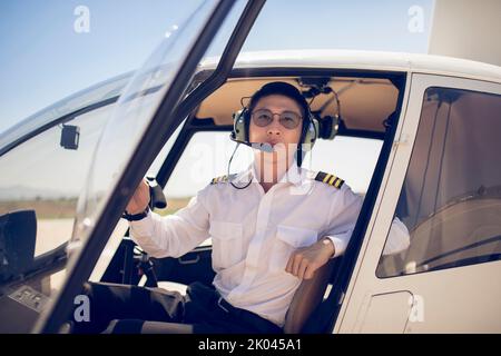 Chinese pilot sitting in helicopter cockpit Stock Photo