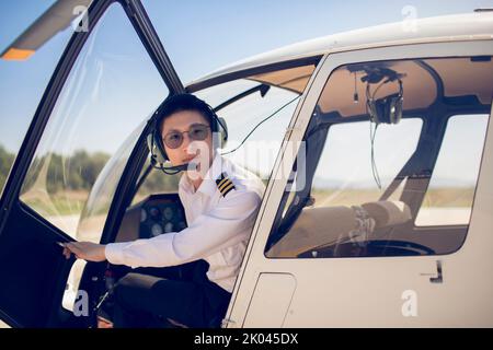 Chinese pilot sitting in helicopter cockpit Stock Photo