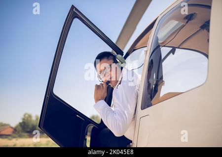 Chinese pilot sitting in helicopter cockpit Stock Photo