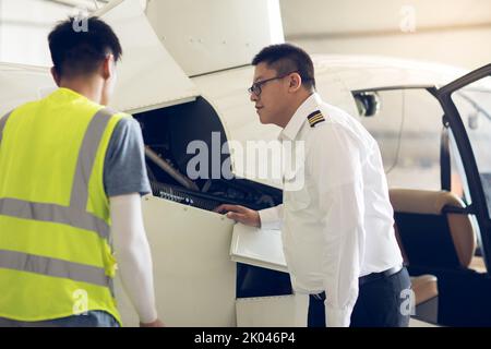 Chinese airplane mechanic checking helicopter Stock Photo