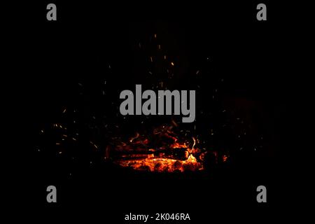 Campfire flame sparks isolated on black background. Fire flames heat energy heap in the night. Fire sparkles isolated on black background Stock Photo
