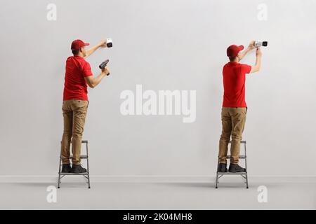 Workers installing security cameras on a wall Stock Photo