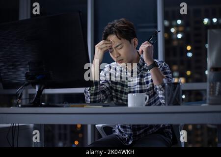 Chinese IT worker working in office at night Stock Photo