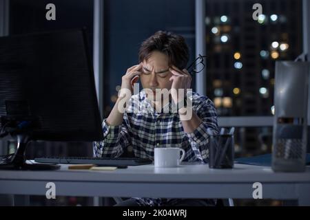 Chinese IT worker working in office at night Stock Photo