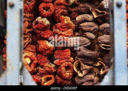 Bunch of dried red paprika and chilli and dried eggplants hanging in the showcase of the oriental market store in Heidelberg, Bavaria, Germany. Dark b Stock Photo