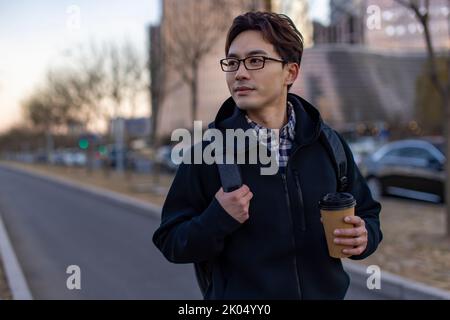 Chinese IT worker holding a cup of coffee Stock Photo