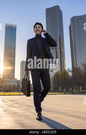 Cheerful Chinese businessman talking on cell phone Stock Photo