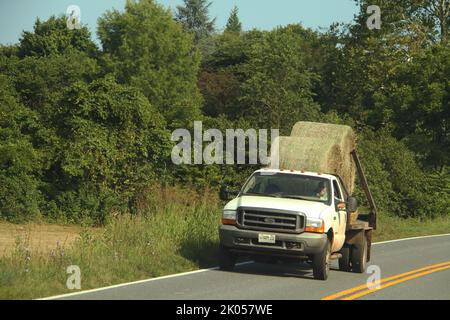 Truck hauling hay bales on a country road in Virginia, USA Stock Photo