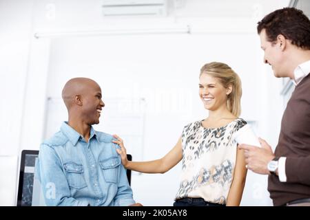 Theyre friends and colleagues. Three business colleagues talking in the workplace. Stock Photo