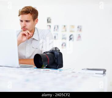 Business man using laptop. Business man holding glasses and using laptop with camera in foreground. Stock Photo