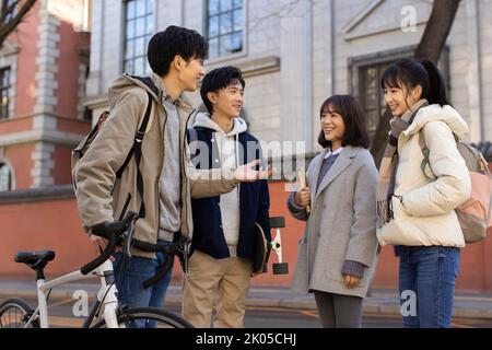 Happy Chinese college students talking on campus Stock Photo