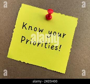 Know your priorities text on yellow notepad with wooden background. Motivational concept. Stock Photo