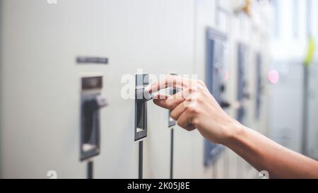 Engineers working to inspect and maintain electrical control cabinets. Stock Photo