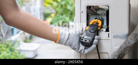 Air conditioner technician checking air conditioner operation Stock Photo