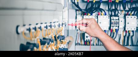 An electrical engineer is inspecting the operation of an electrical control cabinet. maintenance concept Stock Photo