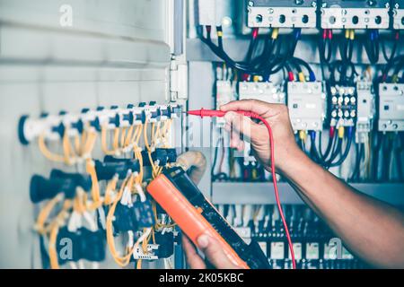 An electrical engineer is inspecting the operation of an electrical control cabinet. maintenance concept Stock Photo