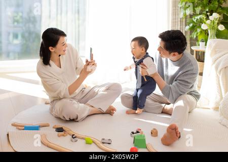 Young Chinese parents playing with baby at home Stock Photo