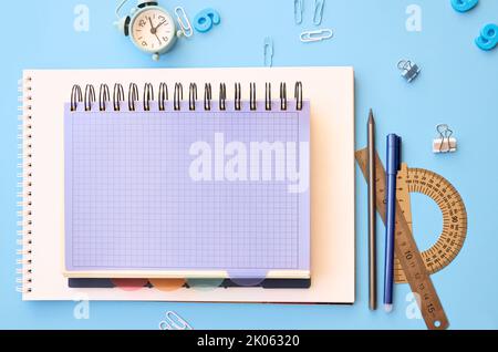 School accessories supplies on blue table, flatlay desk background. Stock Photo