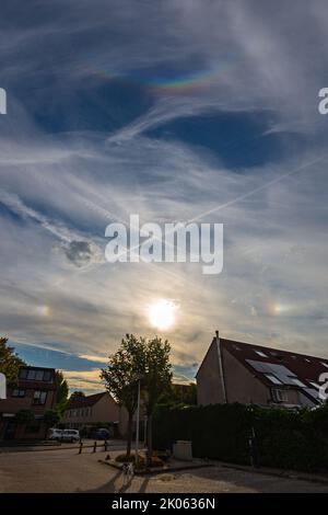 Complex halo phenomenon in the sky with two bright parhelia, 22 degrees circle and circumzenithal arc. Stock Photo