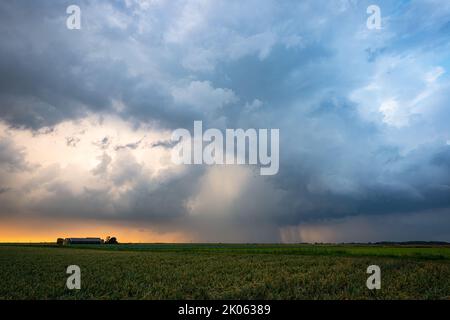 Ominous spectacle as threatening clouds of a thunderstorm pass in the evening light Stock Photo