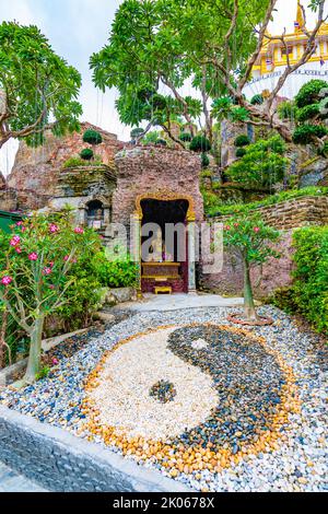 Yin Yang symbol placed in buddhist garden near the Wat Saket temple, Bangkok city, Thailand. Spiritual symbol is placed near the Buddha statue near fr Stock Photo