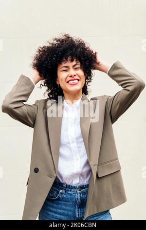 woman smiles happy shaking her curly hair Stock Photo