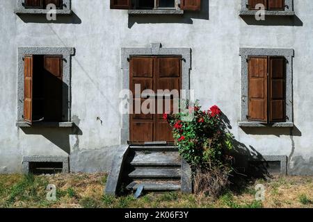 Traditional old house facade with red roses in Les Houches, Chamonix, France Stock Photo