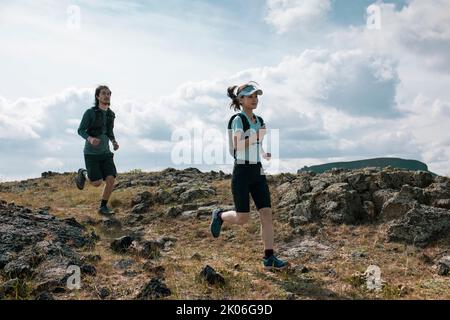 Happy Chinese couple trail running in nature Stock Photo