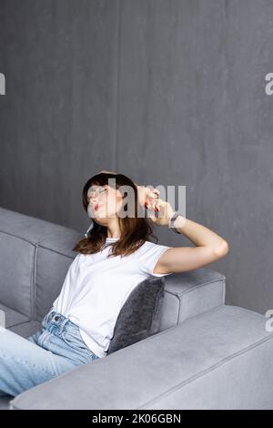 Business woman working from home sitting on couch stretching arms happy and smiling Stock Photo