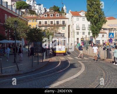 Lisbon, Portugal, October 24, 2021: View of Largo das portas do sol square with old yellow tram at medieval quarter Alfama in Lisbon, sunny day, blue Stock Photo