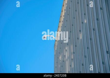 Modern commercial building with cctv security camera in Tucson Arizona. View of a highrise with video surveilance camera installed at the roof for saf Stock Photo