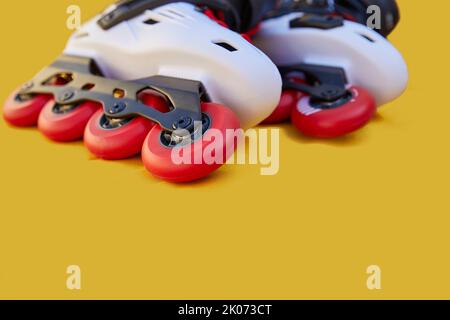 Close-up of inline skate wheels one on top of the other on a yellow background with copyspace Stock Photo