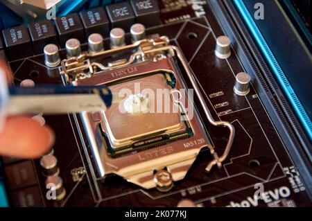 Applying thermal paste to the central processor of the motherboard close up Stock Photo