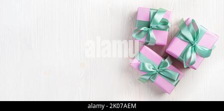 Three pink gift boxes on a light background. The concept of holidays. Stock Photo