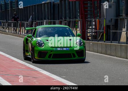 Green racing car Sports car Porsche 911 GT3 RS in pit lane Pit Lane of race track, FIA Formula 1 circuit, Circuit de Spa Francorchamps, Ardennes Stock Photo