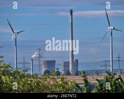The Buschhaus lignite-fired power plant, next to it wind turbines, in the background power lines in the lignite mining area near Schoeningen Stock Photo