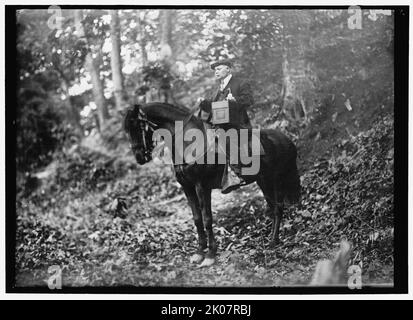 Man on horse in woods, between 1914 and 1917. Photographer with camera in case. Employee of Harris &amp; Ewing photographic studio in Washington, D.C., owned and run by George W. Harris and Martha Ewing. Stock Photo