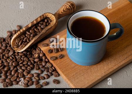 Blue cup of coffee with coffee beans on concrete background Stock Photo