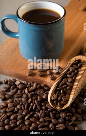 Blue cup of coffee with coffee beans on wooden background Stock Photo