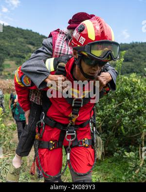 Ya'an, China's Sichuan Province. 10th Sep, 2022. A rescuer transfers a sick elder woman in Xingfu Village of Shimian County, Ya'an City, southwest China's Sichuan Province, Sept. 10, 2022. Credit: Cai Yang/Xinhua/Alamy Live News Stock Photo