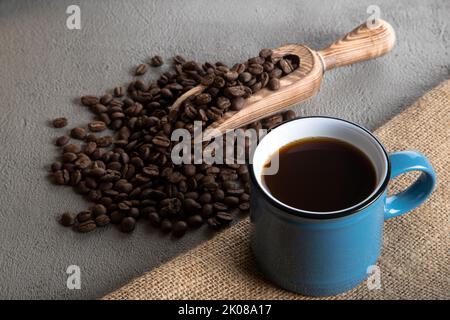 Blue cup of coffee with coffee beans on fabric background Stock Photo