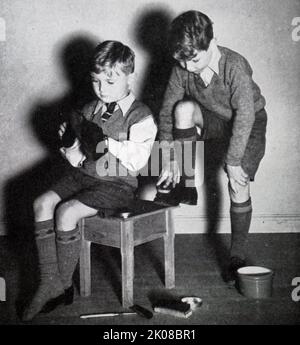 Brothers polishing their shoes for school. Illustration in a newspaper of family life in Britain in the 1950s Stock Photo