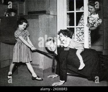 Brother and sister playing with their father. Illustration in a newspaper of family life in Britain in the 1950s Stock Photo