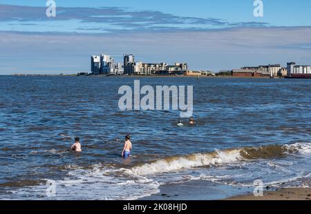 Leith, Edinburgh, Scotland, UK, 10th September 2022. UK Weather: sunshine on Granton. A very warm September day for people to swim in the sea at the small beach at Granton harbour in the Firth of Forth with Platinum Point apartment buildings in the distance. Credit: Sally Anderson/Alamy Live News Stock Photo